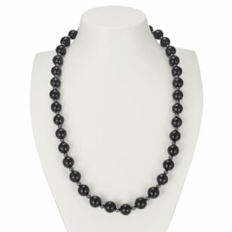 Svart pärlhalsband på vit bakgrund.