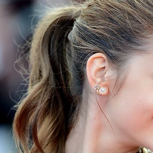 Kvinna med hästsvans och örhänge.