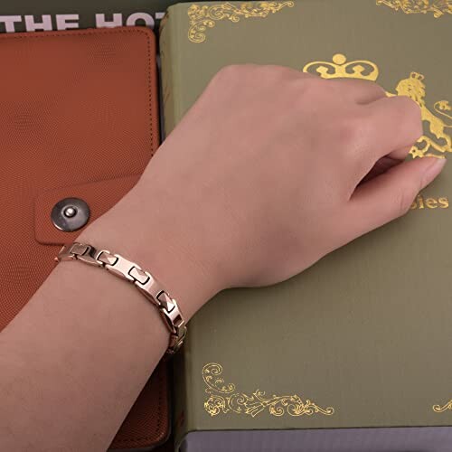 Hand med armband på en bok